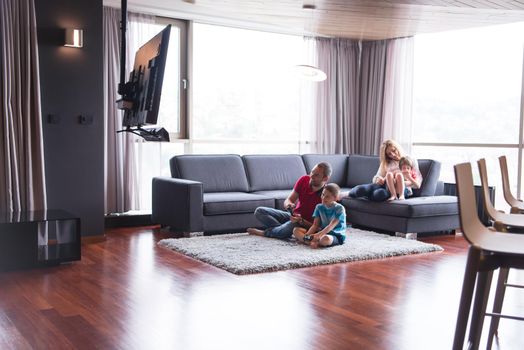 Happy family. Father, mother and children playing a video game Father and son playing video games together on the floor