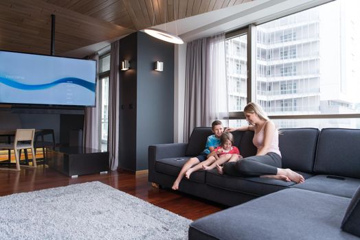 Happy Young Family Playing Together with tablet at home sitting on the sofa