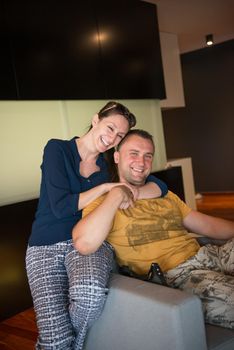 young handsome couple enjoys hugging on the sofa in their luxury home villa