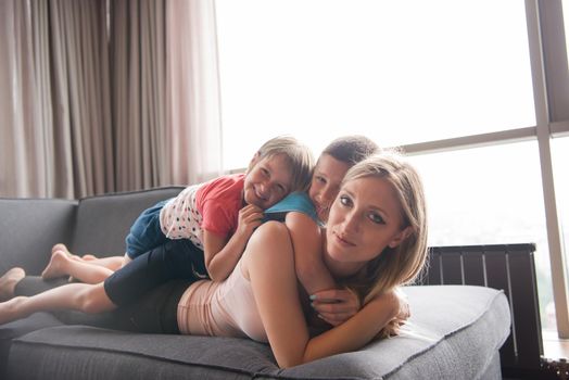 Happy Mother with kids having fun on the floor at home