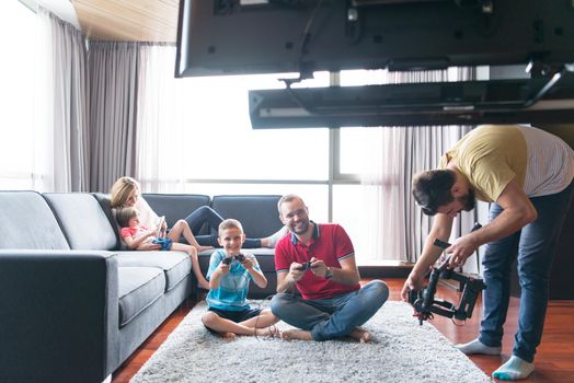 Happy family. Father, mother and children playing a video game Father and son playing video games together on the floor