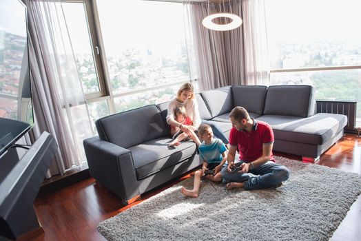 Happy family. Father, mother and children playing a video game Father and son playing video games together on the floor