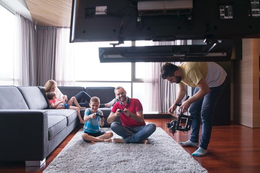 Happy family. Father, mother and children playing a video game Father and son playing video games together on the floor