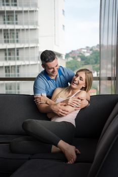 young handsome couple enjoys hugging on the sofa in their luxury home villa