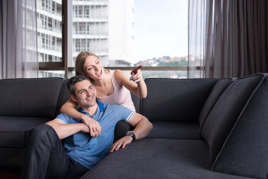 young handsome couple enjoys hugging on the sofa in their luxury home villa