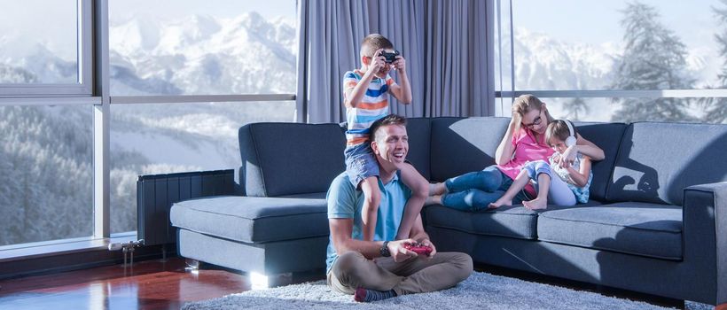 Happy family. Father, mother and children playing a video game Father and son playing video games together on the floor