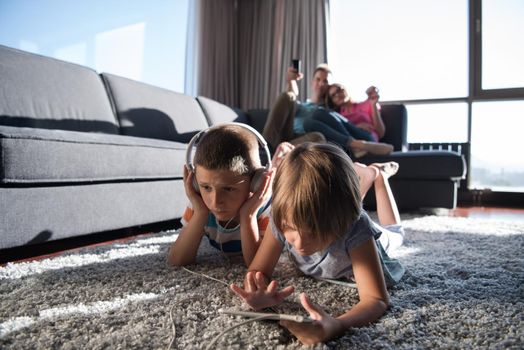 Happy Young Family Playing Together at home.kids using tablet on the floor