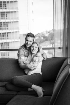 young handsome couple enjoys hugging on the sofa in their luxury home villa