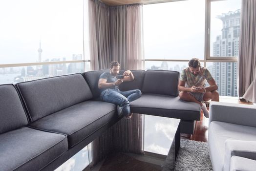 Handsome casual young men using a mobile phones  near the window at home