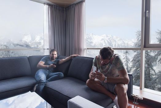 Handsome casual young men using a mobile phones  near the window at home