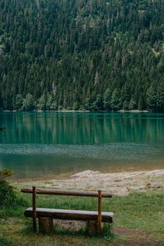 Relax. Rest near lake. Wooden bench overlooking the lake and mountains. Beautiful mystical lake. Black Lake, Durmitor National Park. Montenegro