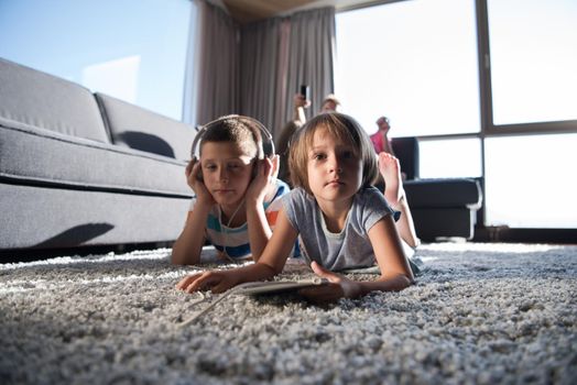 Happy Young Family Playing Together at home.kids using tablet on the floor