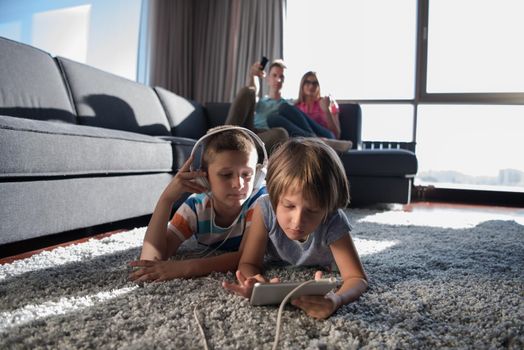 Happy Young Family Playing Together at home.kids using tablet on the floor