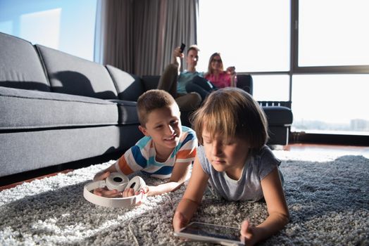 Happy Young Family Playing Together at home.kids using tablet on the floor