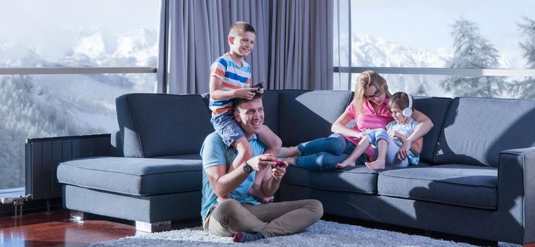 Happy family. Father, mother and children playing a video game Father and son playing video games together on the floor