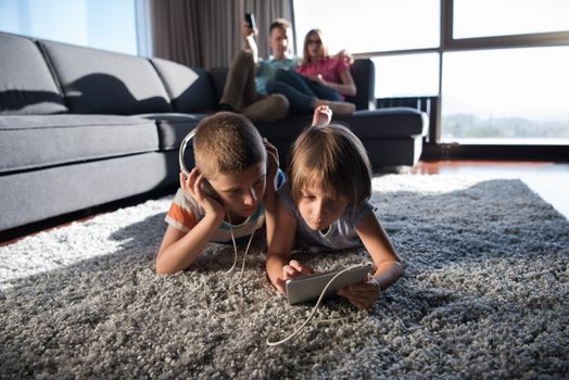 Happy Young Family Playing Together at home.kids using tablet on the floor