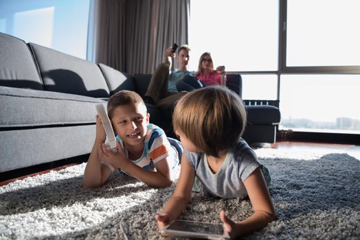 Happy Young Family Playing Together at home.kids using tablet on the floor