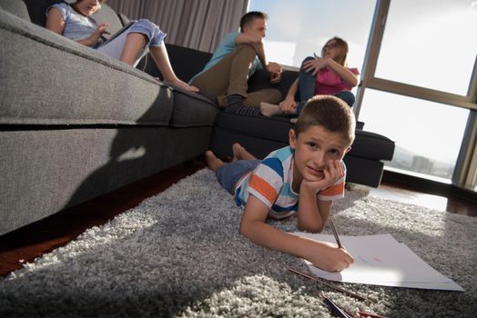 Happy Young Family Playing Together at home on the floor using a tablet and a children's drawing set