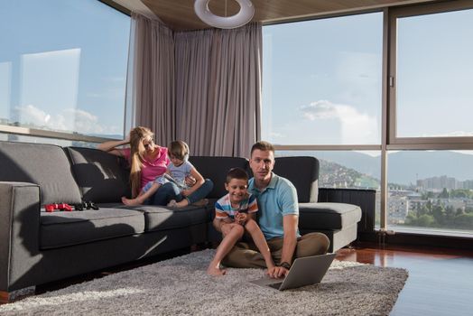 Happy family. Father, mother and children playing a video game Father and son playing video games together on the floor