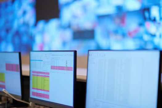 Empty interior of big modern security system control room, workstation with multiple displays, monitoring room with at security data center  Empty office, desk, and chairs at a main CCTV security data center