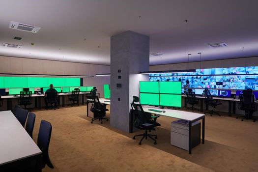 Group of Security data center operators working in a CCTV monitoring room looking on multiple monitors  Officers Monitoring Multiple Screens for Suspicious Activities  Team working on the System Control Room