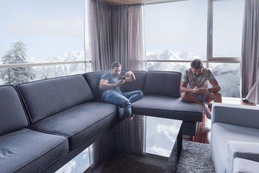 Handsome casual young men using a mobile phones  near the window at home