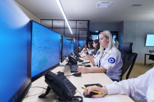 group of female security operators working in a data system control room  Technical Operators Working at  workstation with multiple displays, security guards working on multiple monitors in surveillance room, monitoring cctv and discussing