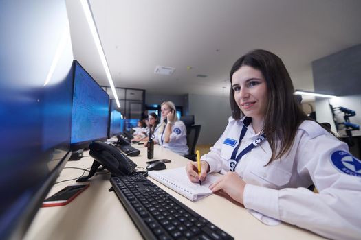 group of female security operators working in a data system control room  Technical Operators Working at  workstation with multiple displays, security guards working on multiple monitors in surveillance room, monitoring cctv and discussing