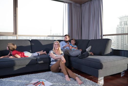 Happy Young Family Playing Together at home on the floor using a tablet and a children's drawing set