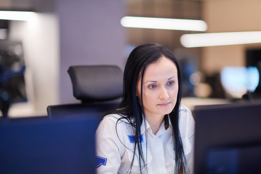 Female security operator working in a data system control room offices Technical Operator Working at  workstation with multiple displays, security guard working on multiple monitors