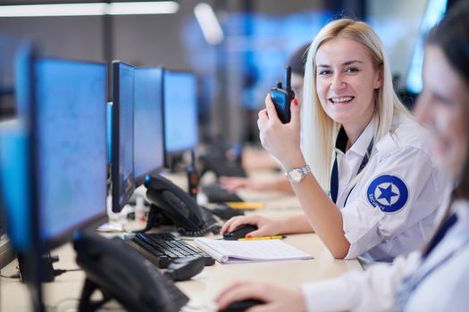 Female security operator working in a data system control room offices Technical Operator Working at  workstation with multiple displays, security guard working on multiple monitors