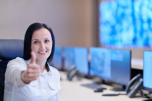 portrait of female security operator while working in a data system control room offices Technical Operator Working at  workstation with multiple displays, security guard working on multiple monitors