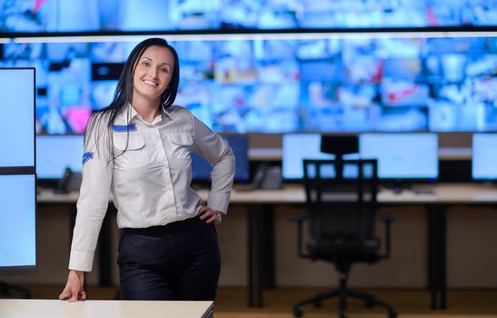 portrait of female security operator while working in a data system control room offices Technical Operator Working at  workstation with multiple displays, security guard working on multiple monitors