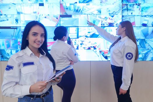 group of female security operators working in a data system control room  Technical Operators Working at  workstation with multiple displays, security guards working on multiple monitors in surveillance room, monitoring cctv and discussing