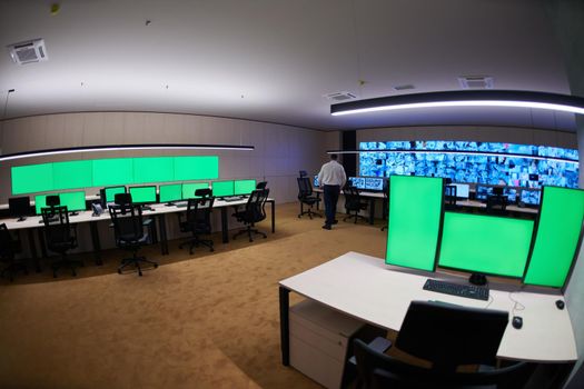 Group of Security data center operators working in a CCTV monitoring room looking on multiple monitors  Officers Monitoring Multiple Screens for Suspicious Activities  Team working on the System Control Room