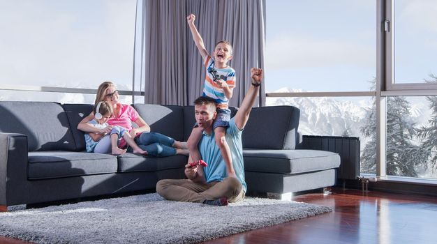 Happy family. Father, mother and children playing a video game Father and son playing video games together on the floor