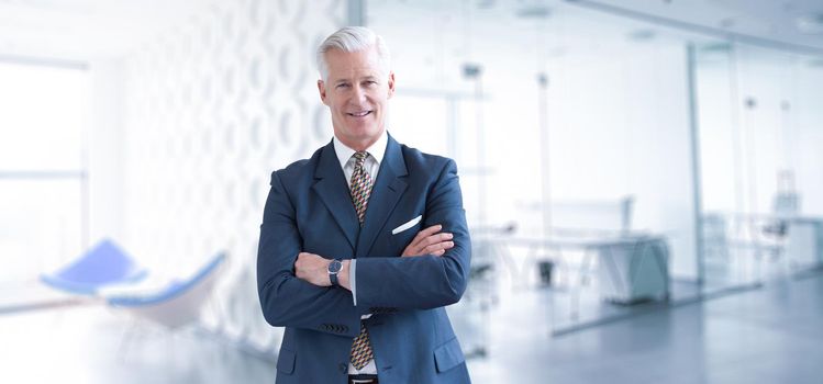 Portrait of senior businessman in front of his modern office