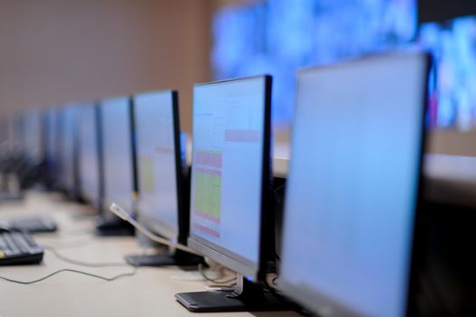 Empty interior of big modern security system control room, workstation with multiple displays, monitoring room with at security data center  Empty office, desk, and chairs at a main CCTV security data center