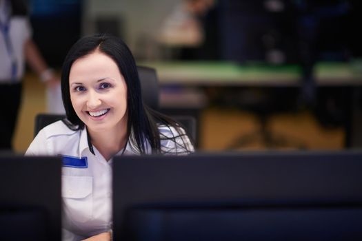 portrait of female security operator while working in a data system control room offices Technical Operator Working at  workstation with multiple displays, security guard working on multiple monitors