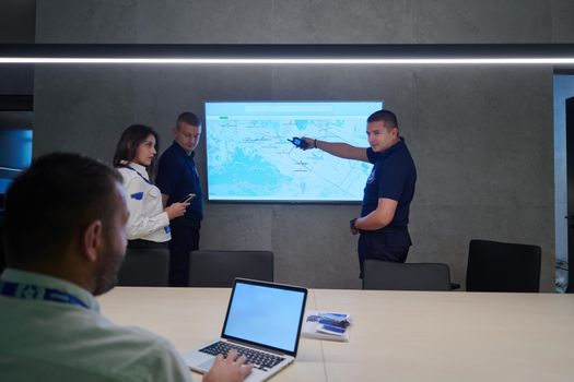 Group of Security data center operators working in a CCTV monitoring room looking on multiple monitors  Officers Monitoring Multiple Screens for Suspicious Activities  Team working on the System Control Room