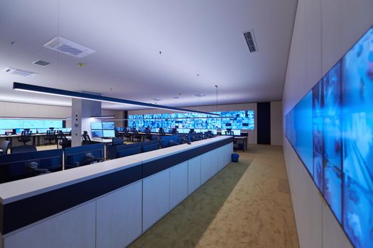 Empty interior of big modern security system control room, workstation with multiple displays, monitoring room with at security data center  Empty office, desk, and chairs at a main CCTV security data center