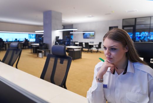 Female security operator working in a data system control room offices Technical Operator Working at  workstation with multiple displays, security guard working on multiple monitors