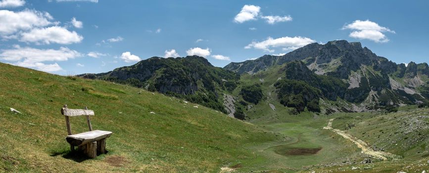 Mountain landscape. Alps with green grass and bright blue sky. Idyllic panorama. Tourism concept. Hiking. Vacation in Europe. Relax in the open air and the spirit of adventure. Ecology of nature.