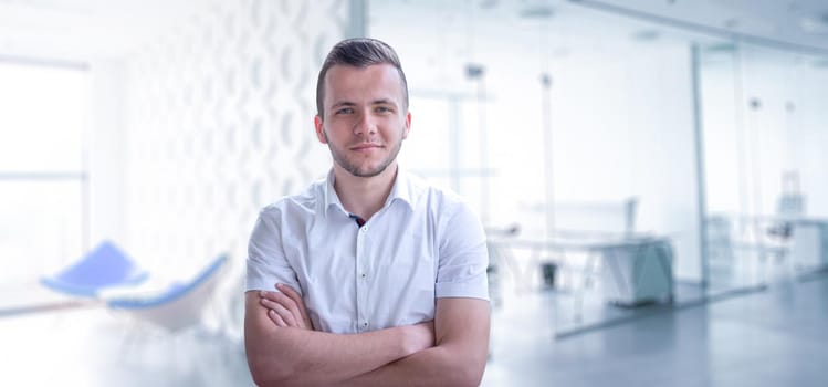 Portrait of young junior businessman in front of his big modern office