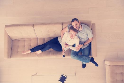 top view of happy romantic couple watching television together in their luxury home