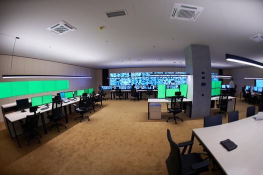 Group of Security data center operators working in a CCTV monitoring room looking on multiple monitors  Officers Monitoring Multiple Screens for Suspicious Activities  Team working on the System Control Room