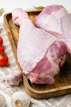 Raw organic turkey legs with ingredients for cooking set, on gray stone table background