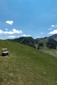 Mountain landscape. Alps with green grass and bright blue sky. Idyllic panorama. Tourism concept. Hiking. Vacation in Europe. Relax in the open air and the spirit of adventure. Ecology of nature.