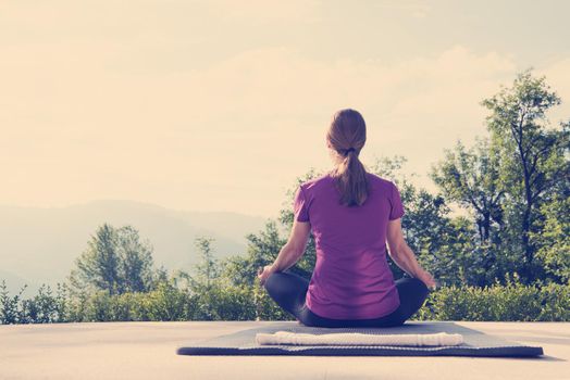 handsome woman doing morning yoga exercises in front of her luxury home villa