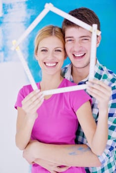 happy young couple paint in green and blue color white wall of their new home